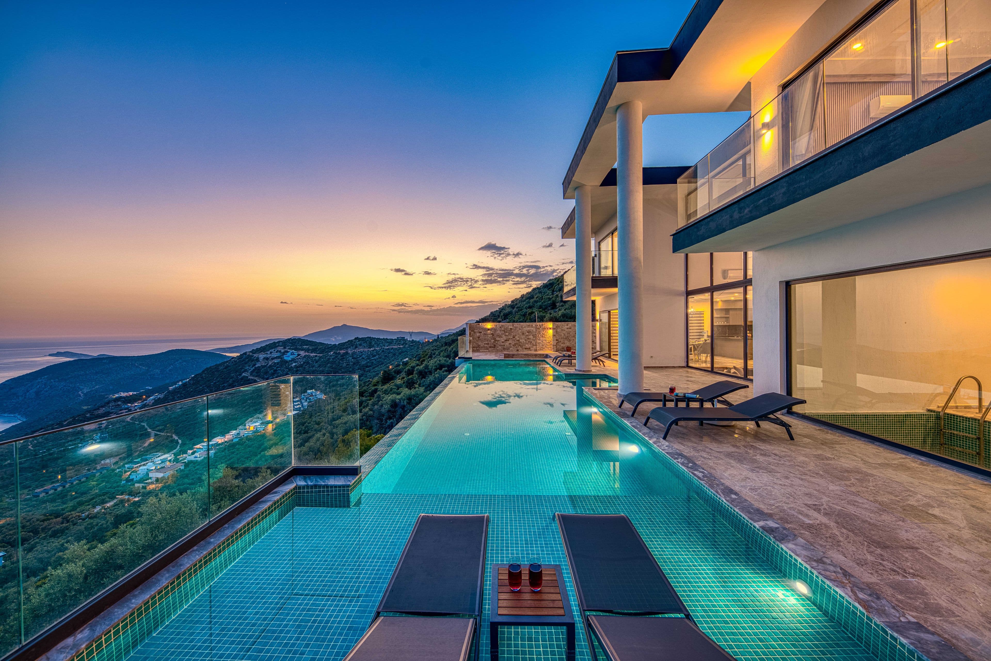 Modern seaside villa with an infinity pool at sunset