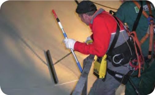 Operator carrying out high-voltage pore detection on the first coat